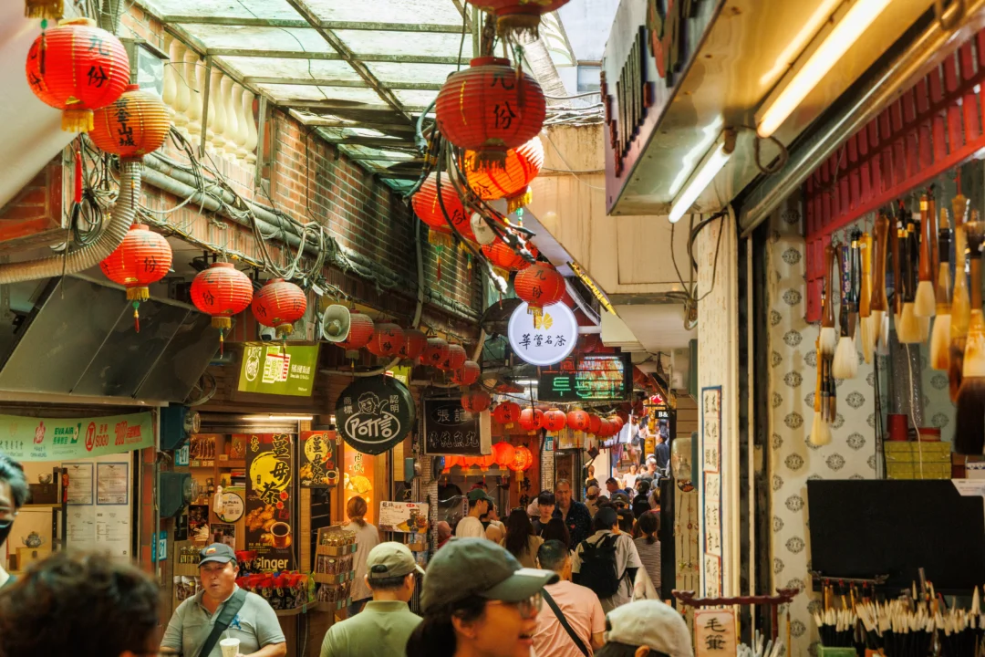 Red paper lanterns hanging over the crowded narrow lane of Jiufen Old Street market in Taiwan