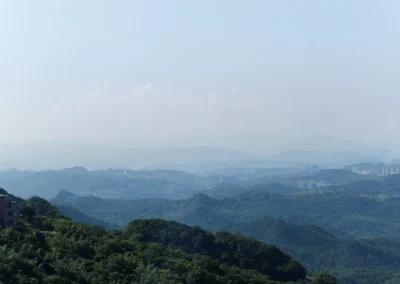 View from Jiufen hilltop over orange temple rooftops, forested hills and the blue Pacific coast