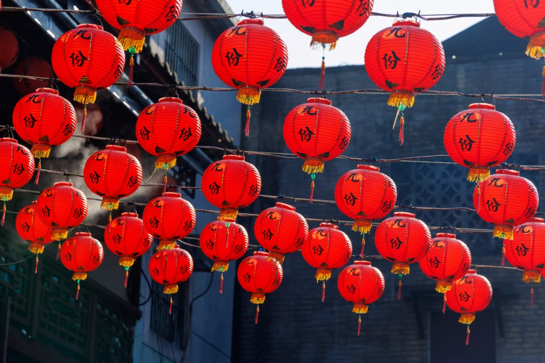 Grid of red Jiufen lanterns filling the entire frame with Chinese characters and golden tassels