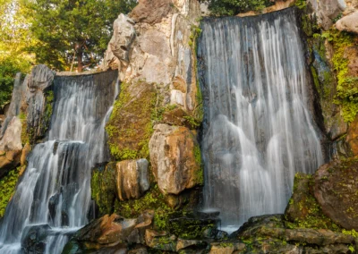 Twin waterfalls in Longshan Temple gardens with golden light catching the surrounding trees