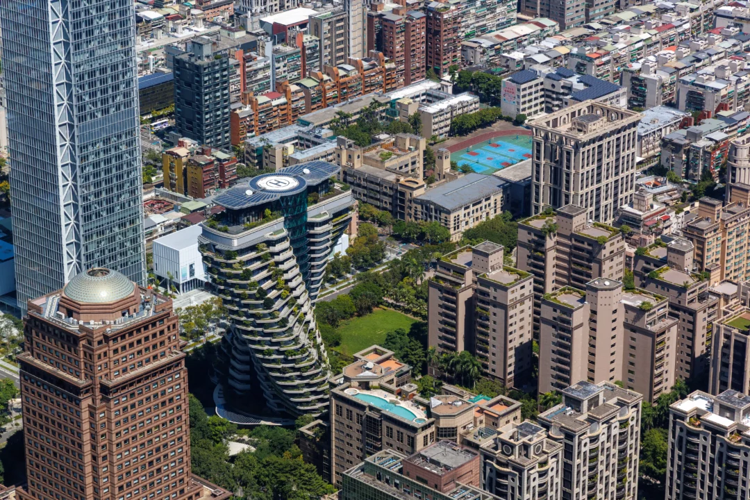 Aerial close-up of the Agora Garden twin towers with their spiral planted terraces seen from Taipei 101