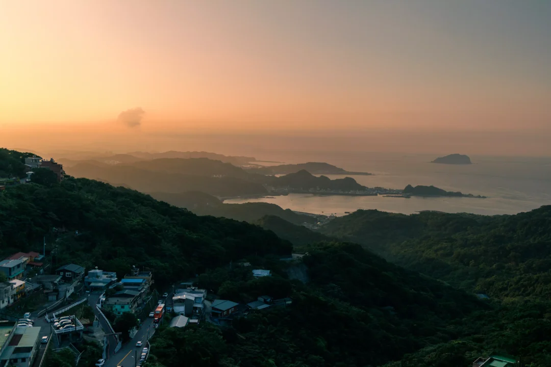 Jiufen bay and island at sunset with golden light on the water and layered headlands