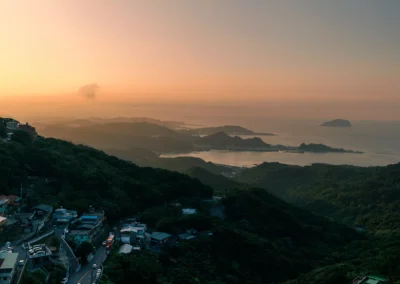 Jiufen bay and island at sunset with golden light on the water and layered headlands