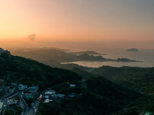 Jiufen bay and island at sunset with golden light on the water and layered headlands