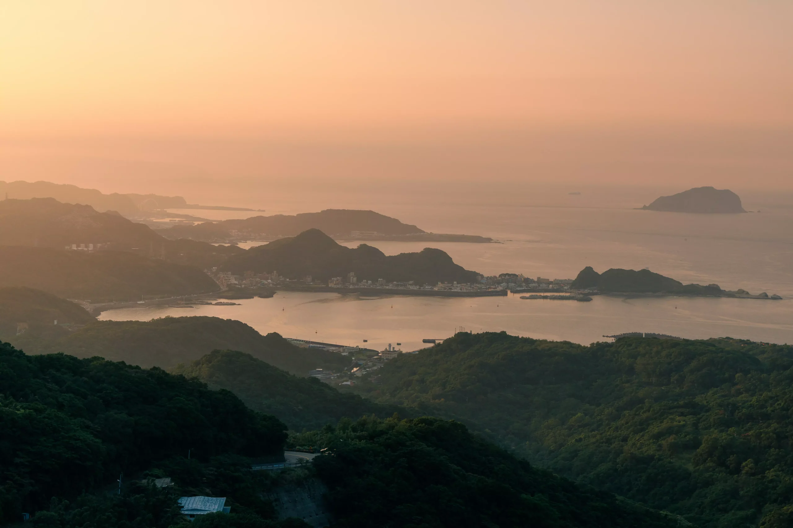 Ornate facade of Longshan Temple Taipei with colourful dragons and tiled rooftop against blue sky