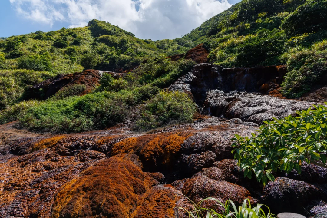 Iron-red volcanic mineral deposits and rust-coloured rock formations at Xiaoyoukeng in Yangmingshan National Park Taiwan