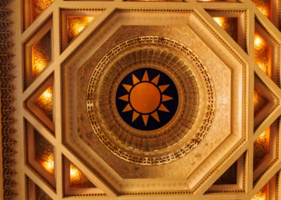 Ornate octagonal ceiling inside Chiang Kai-shek Memorial Hall with blue and orange sun motif and warm amber lighting