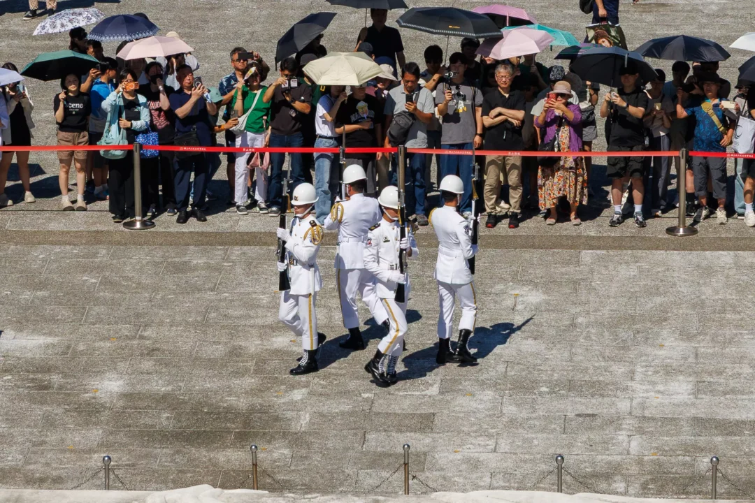 Four military honour guards in white uniforms marching during the changing of the guard ceremony at Chiang Kai-shek Memorial Hall, Taipei