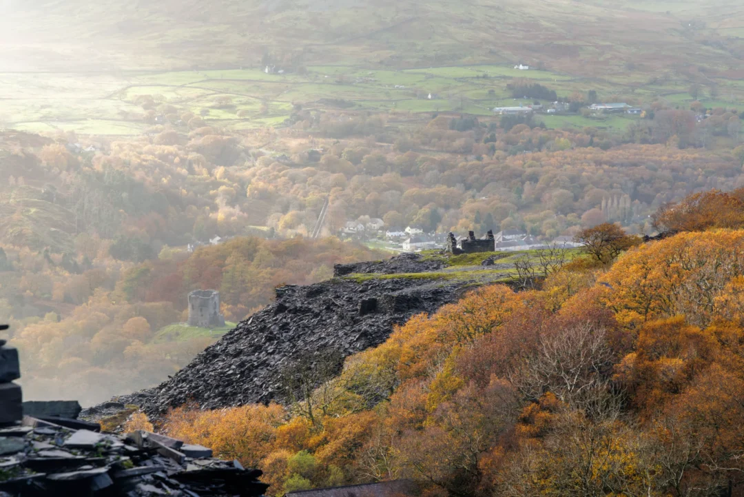 A panoramic high-angle view looking down at Llyn Peris lake nestled between steep, rugged mountain slopes.