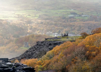 A panoramic high-angle view looking down at Llyn Peris lake nestled between steep, rugged mountain slopes.