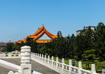 Stone carved balustrade post in the foreground with the orange roofline of the National Concert Hall visible above green trees