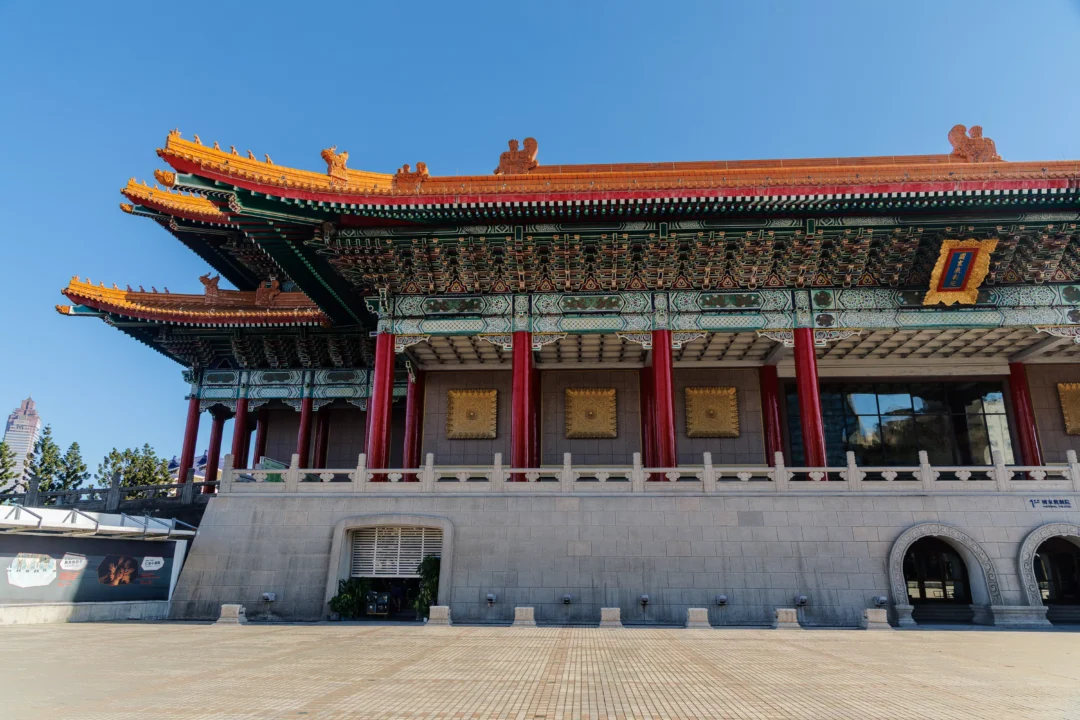 Close-up of the National Concert Hall facade in Taipei showing ornate roof tiers, red columns and gold decorative panels