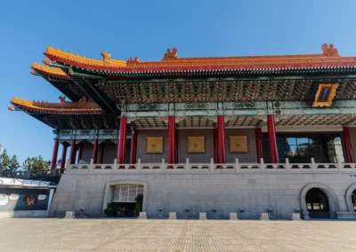 Close-up of the National Concert Hall facade in Taipei showing ornate roof tiers, red columns and gold decorative panels