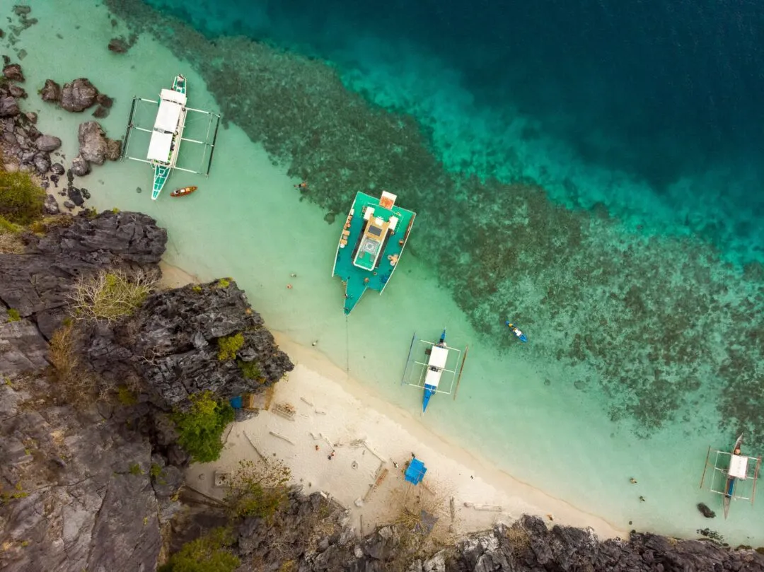 Aerial anchored bangkas reef gradient El Nido