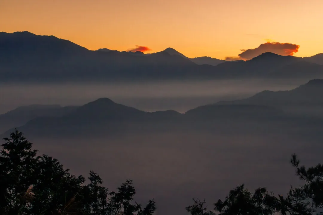 Vivid red and orange burning-cloud sunrise over a mountain silhouette, Alishan, Taiwan