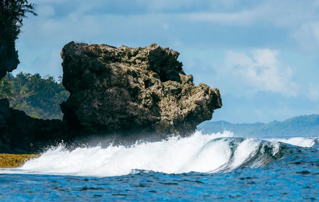Dramatic wave breaking rock arch siargao