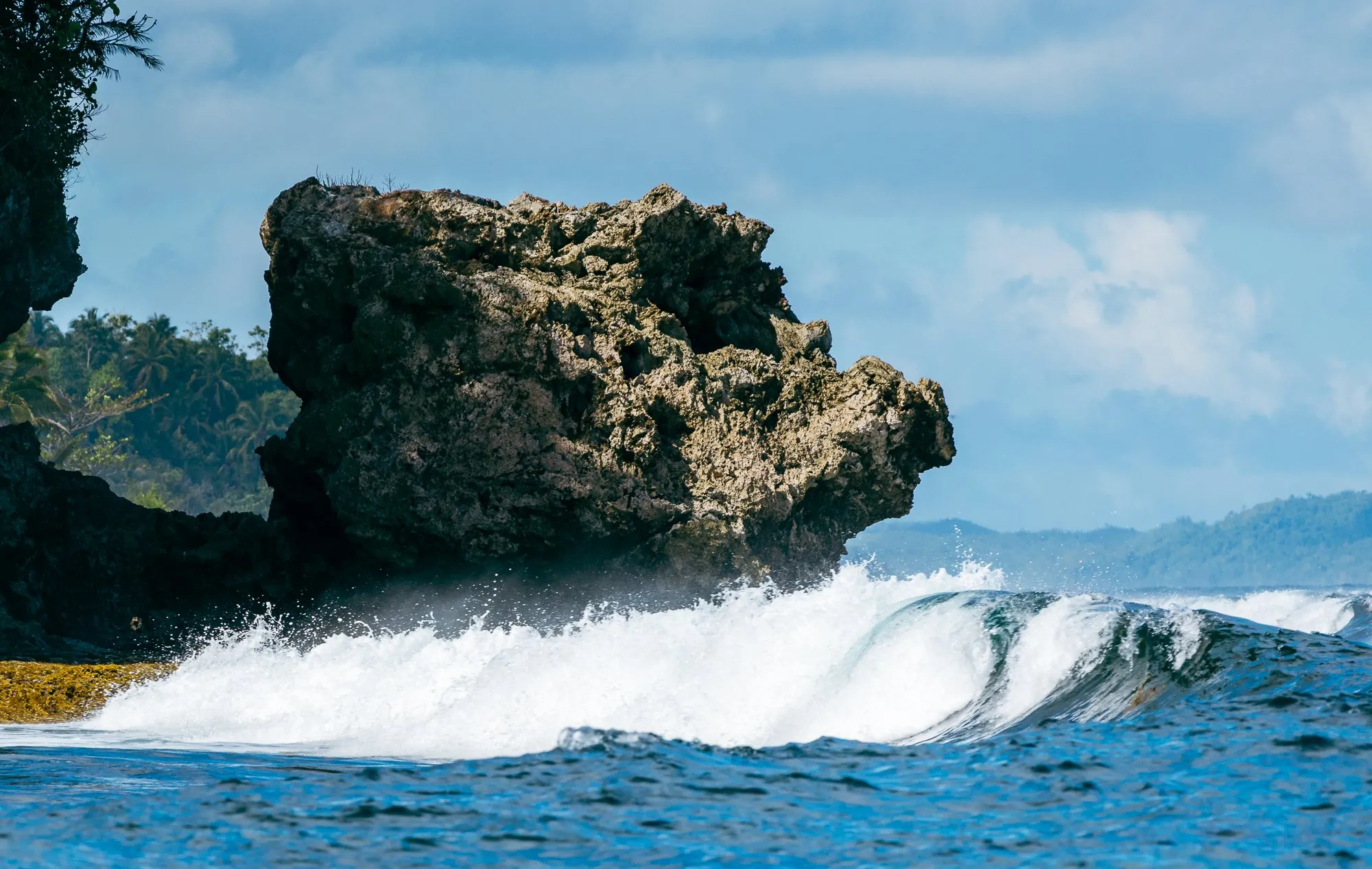 Dramatic wave breaking rock arch siargao