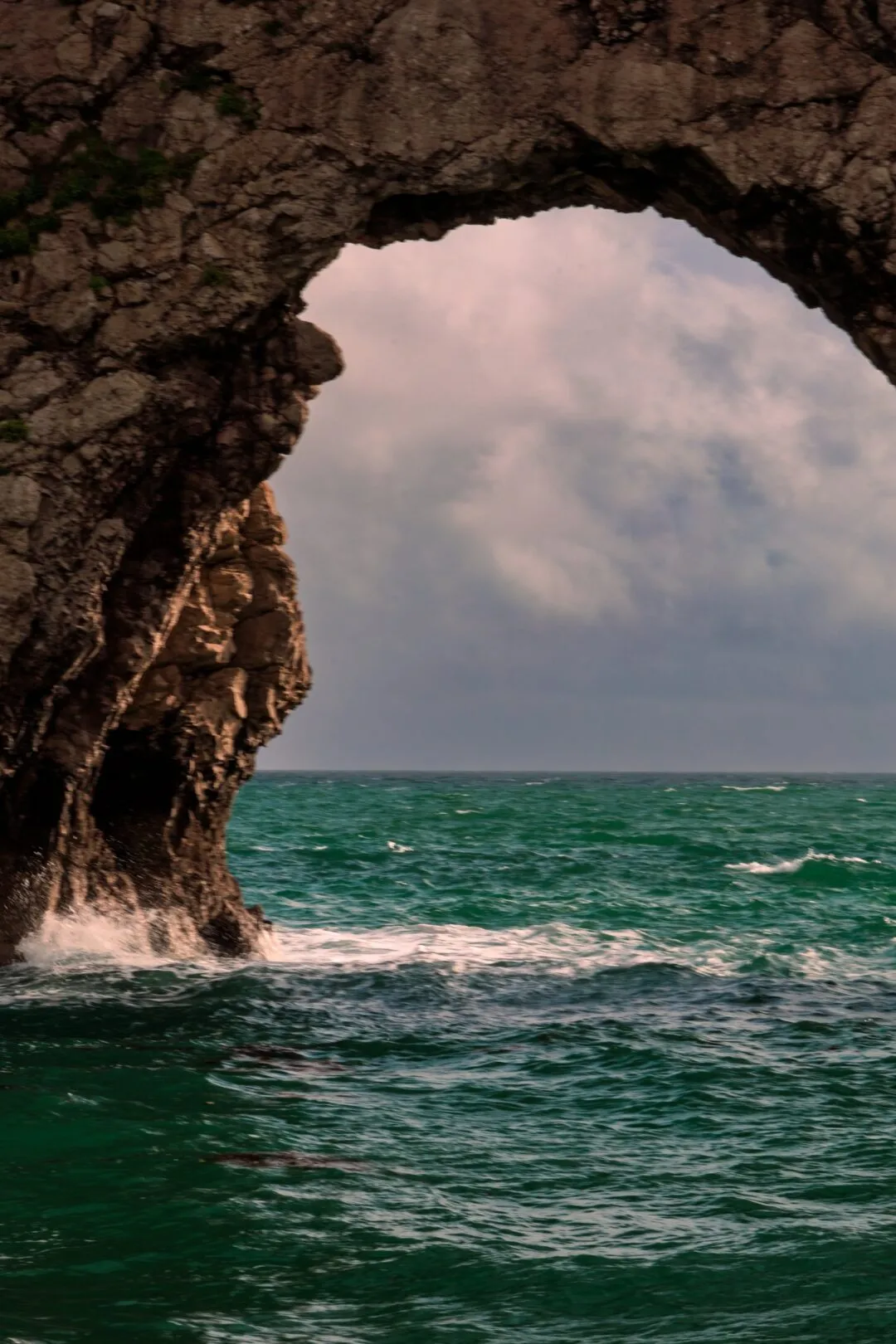 Durdle door arch stormy sky