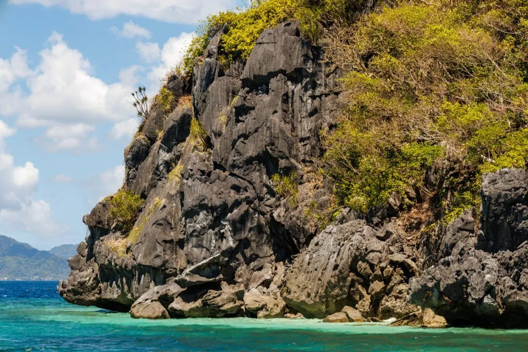 Dynamic kayakers tour boat dramatic cliffs El Nido