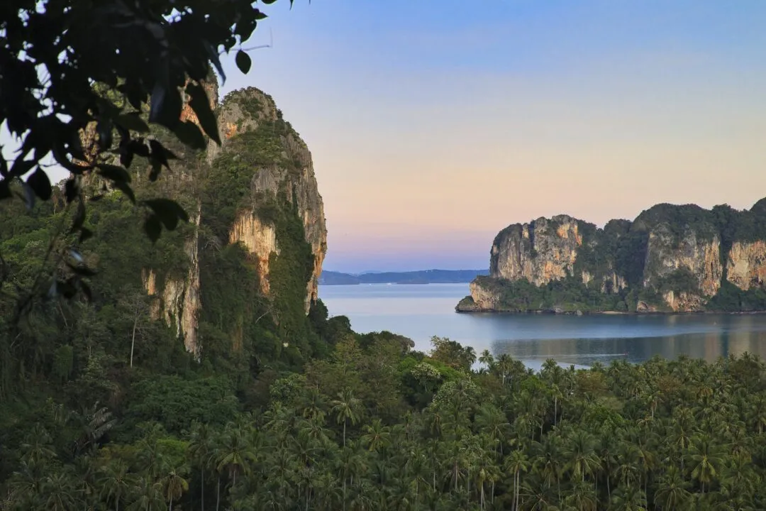 A golden-hour elevated view of a bay flanked by two karst peaks in Thailand.