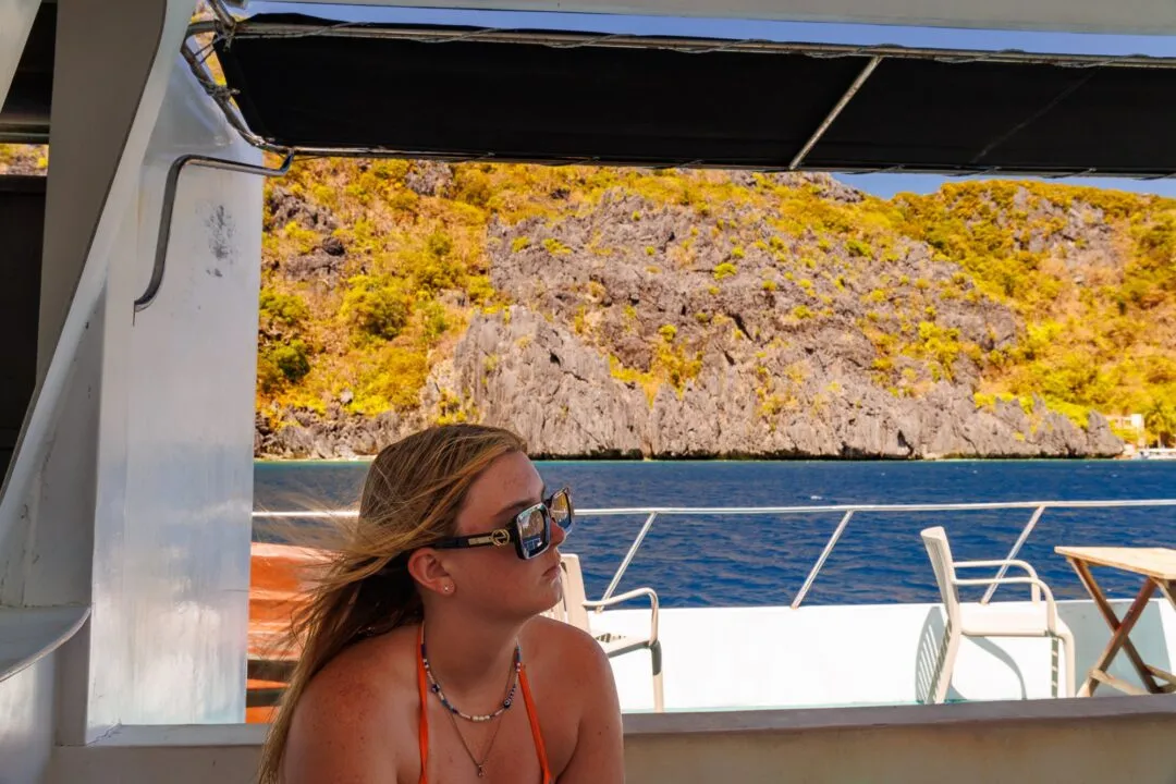 Golden lit candid portrait boat awning cliffs El Nido