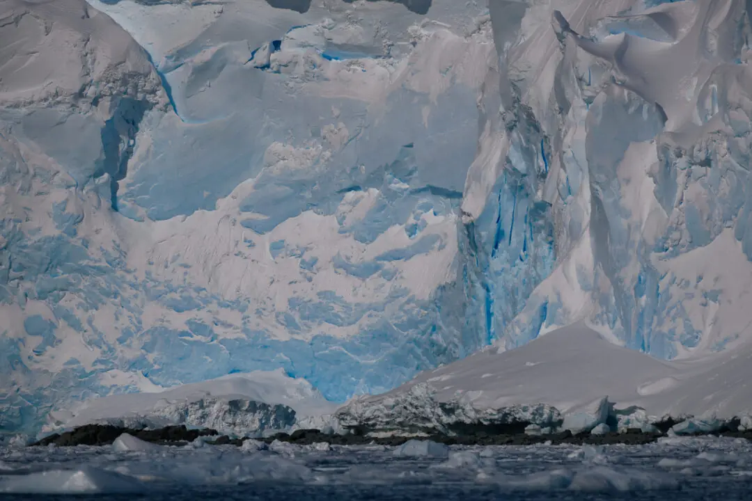 Jagged dark rock peak knifing through a deep blue sky, Antarctic Peninsula