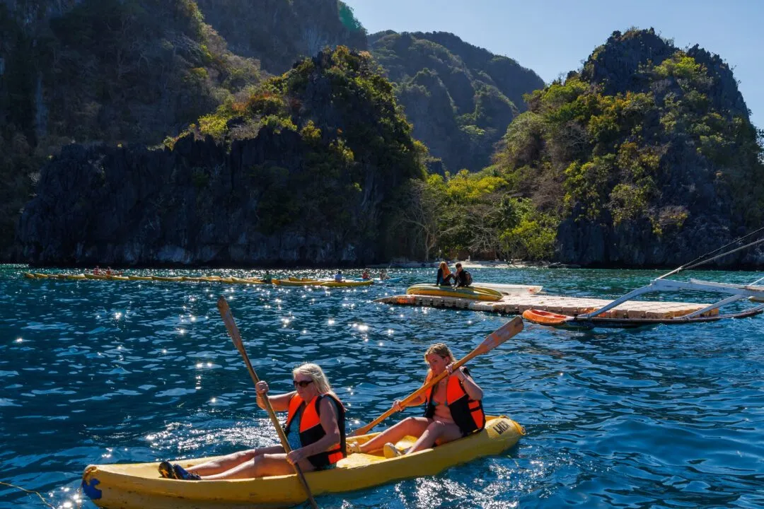 Kayakers framed cliffs mountain glimpse El Nido