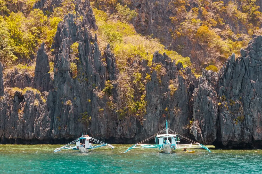 Limestone pinnacles anchored boats scale El Nido
