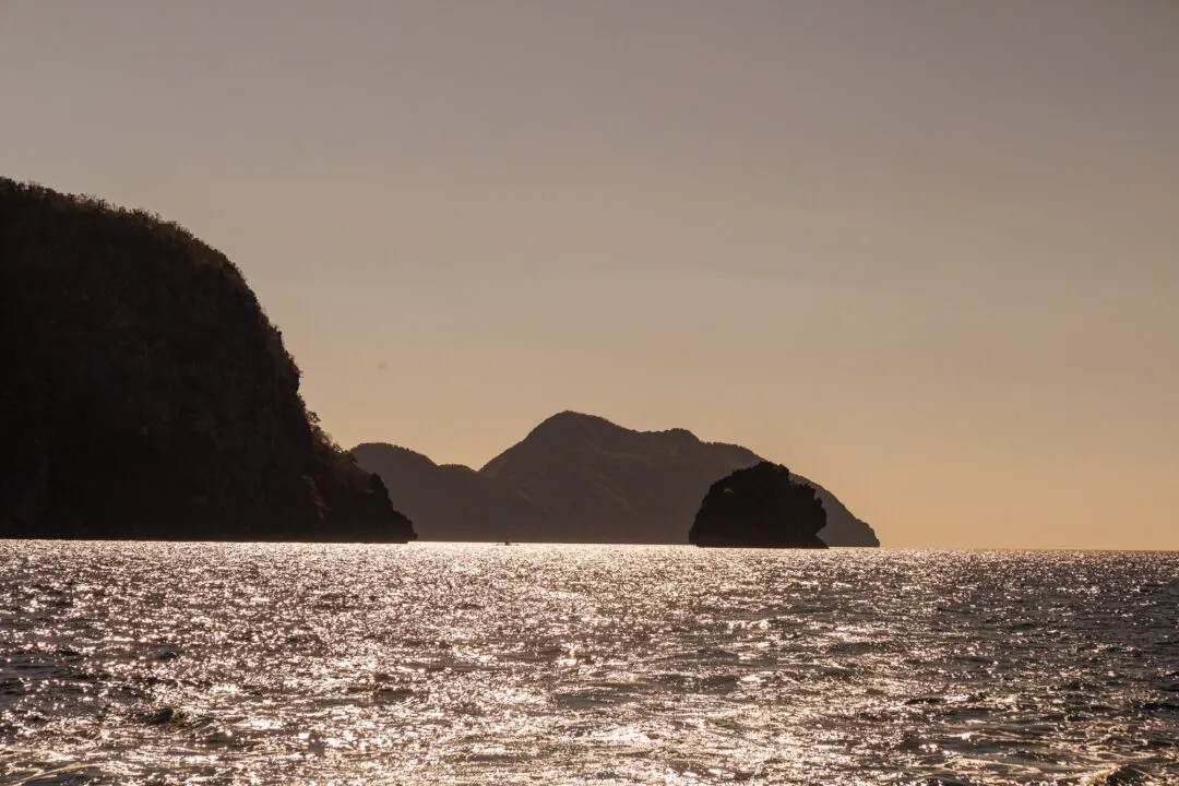 Minimalist karst islands silhouette glittering water El Nido