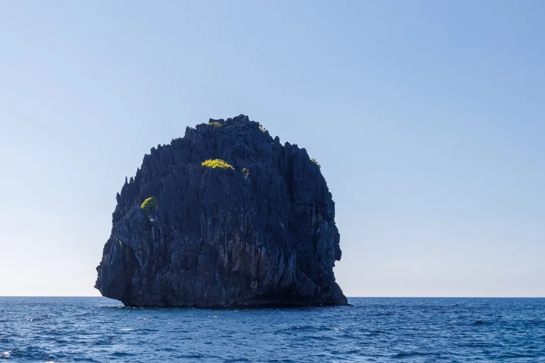 Minimalist silhouette solitary rock islet El Nido