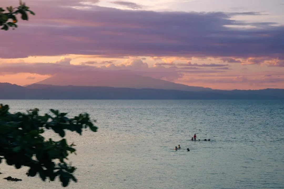 Painterly sunset swimmers mountain silhouette cebu