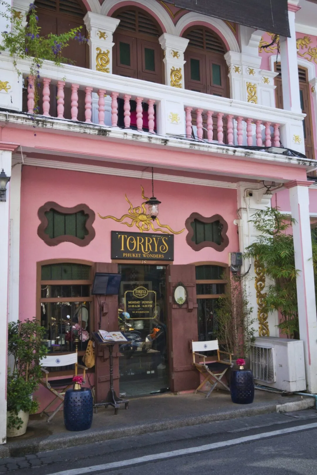 An ornate pink heritage building housing a café in Phuket Old Town, Thailand.