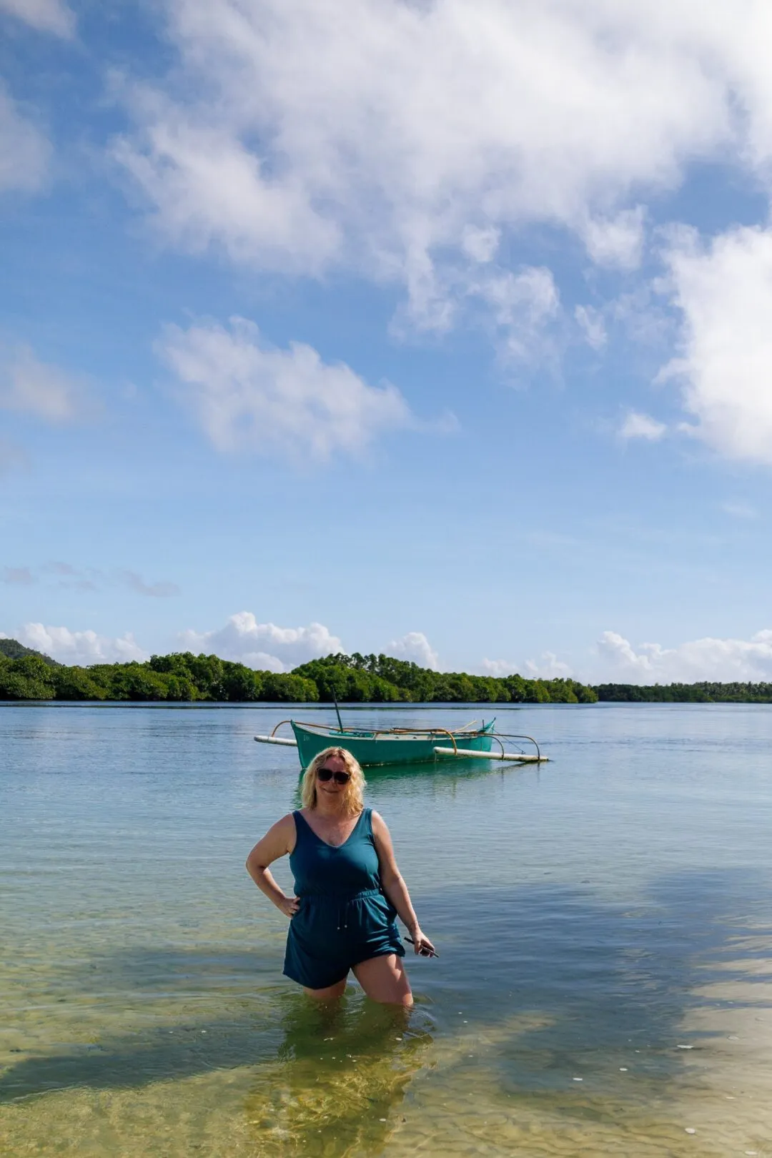 Portrait woman wading green outrigger boat siargao