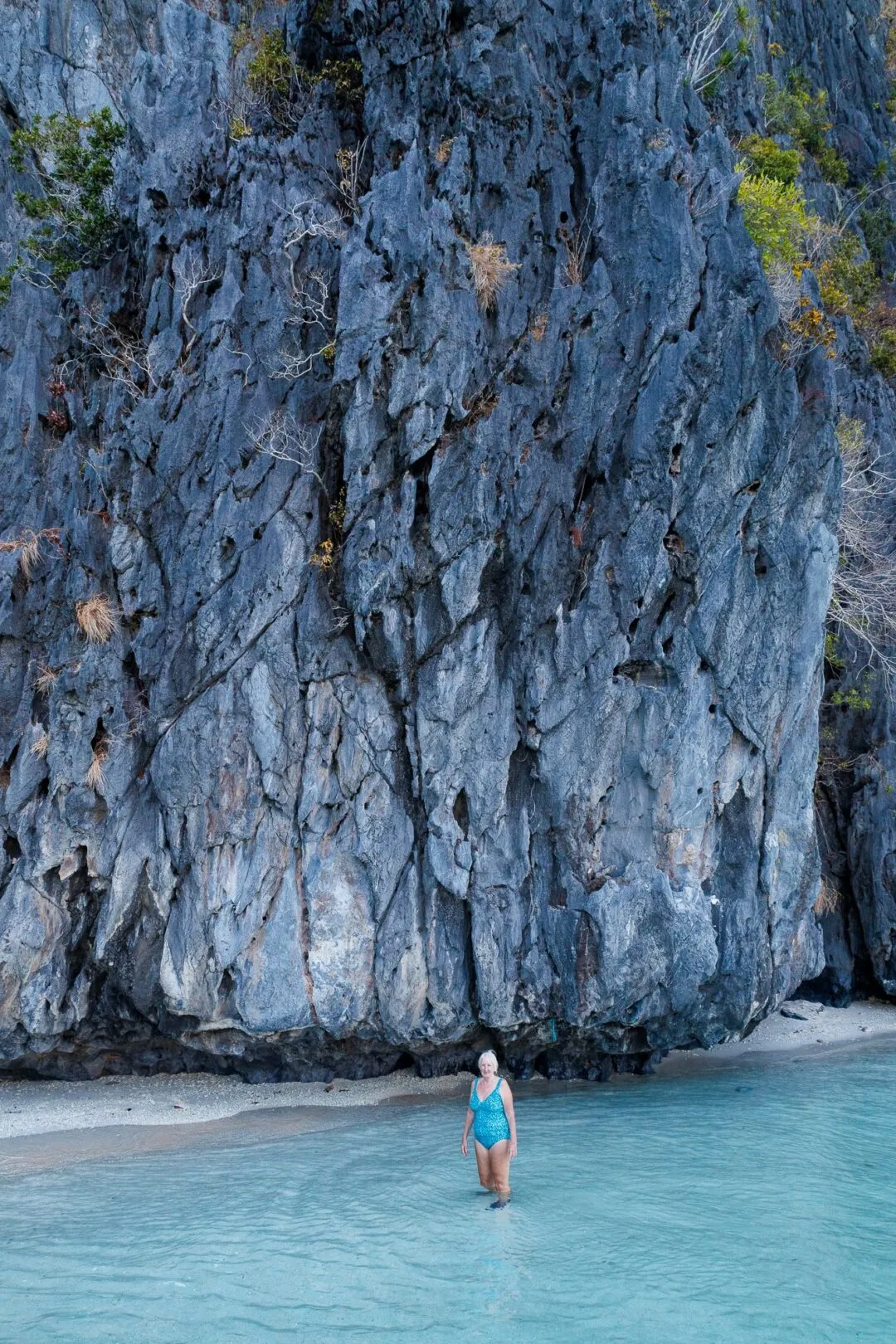 Scale contrast swimmer limestone wall El Nido