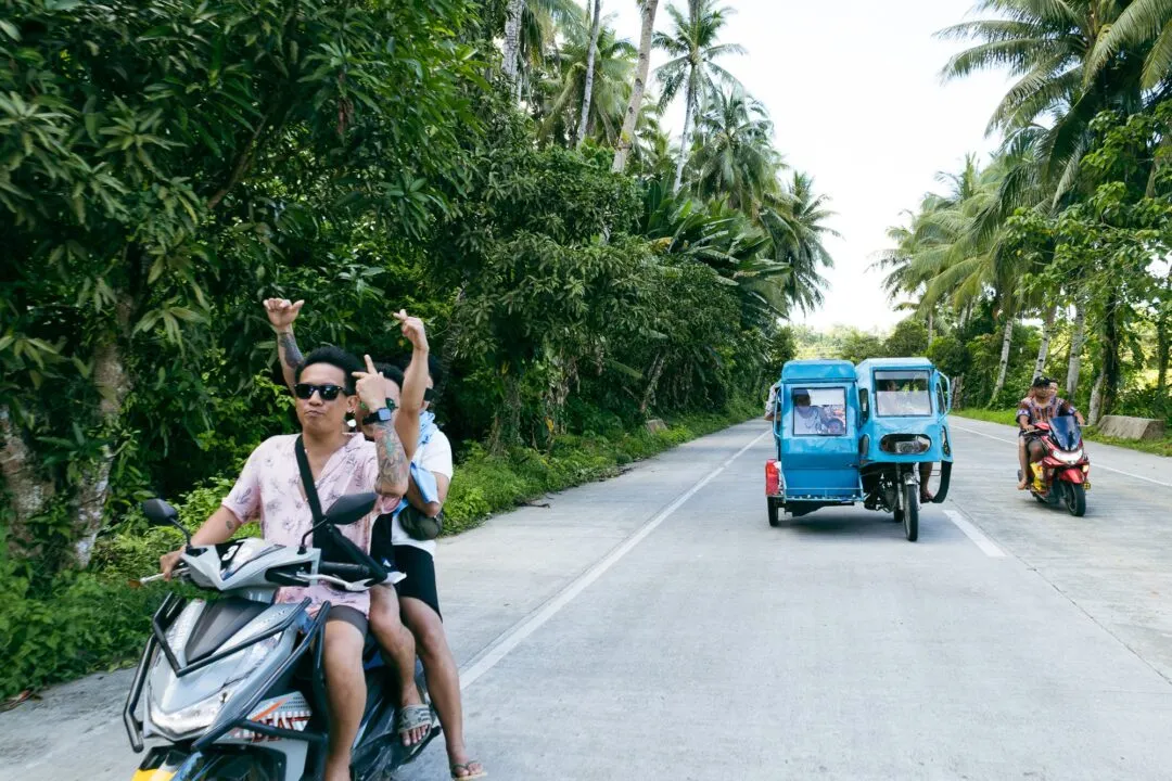 Scooter convoy palm lined road siargao