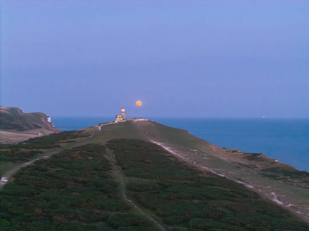 Seven sisters moon over headland