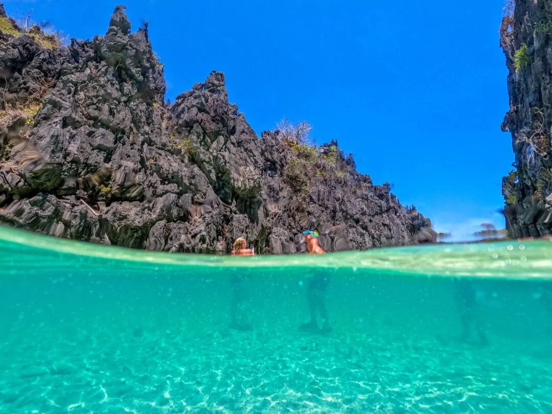 Split shot lagoon cliff snorkelers scale El Nido