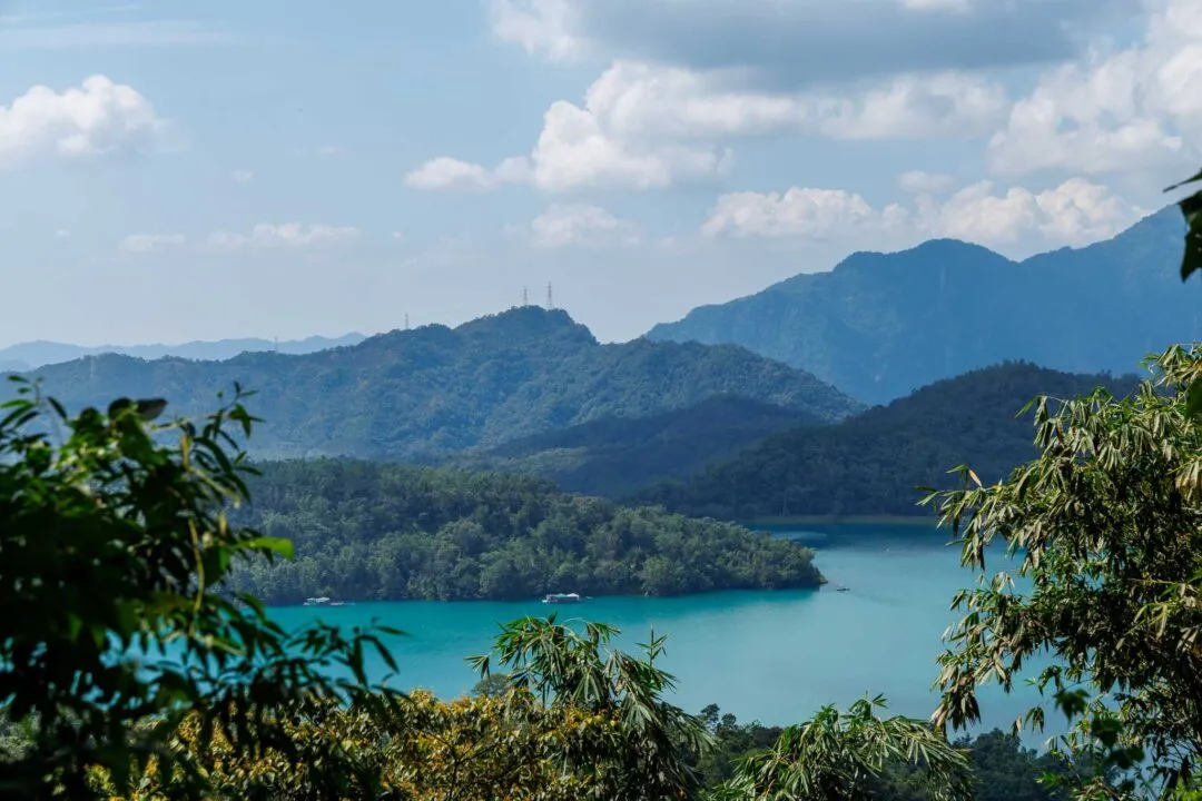 Vivid turquoise lake framed through tree branches, Sun Moon Lake, Taiwan