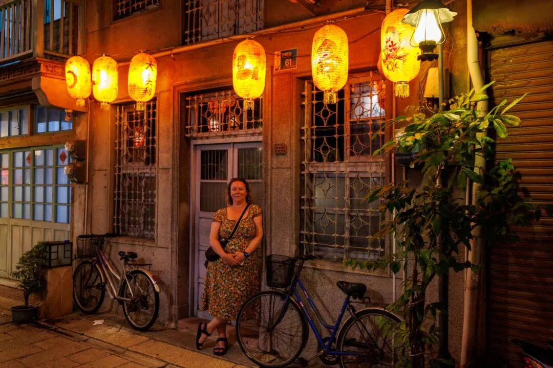 Row of warm lanterns hanging symmetrically over an old doorway at night, Shennong Street, Tainan, Taiwan