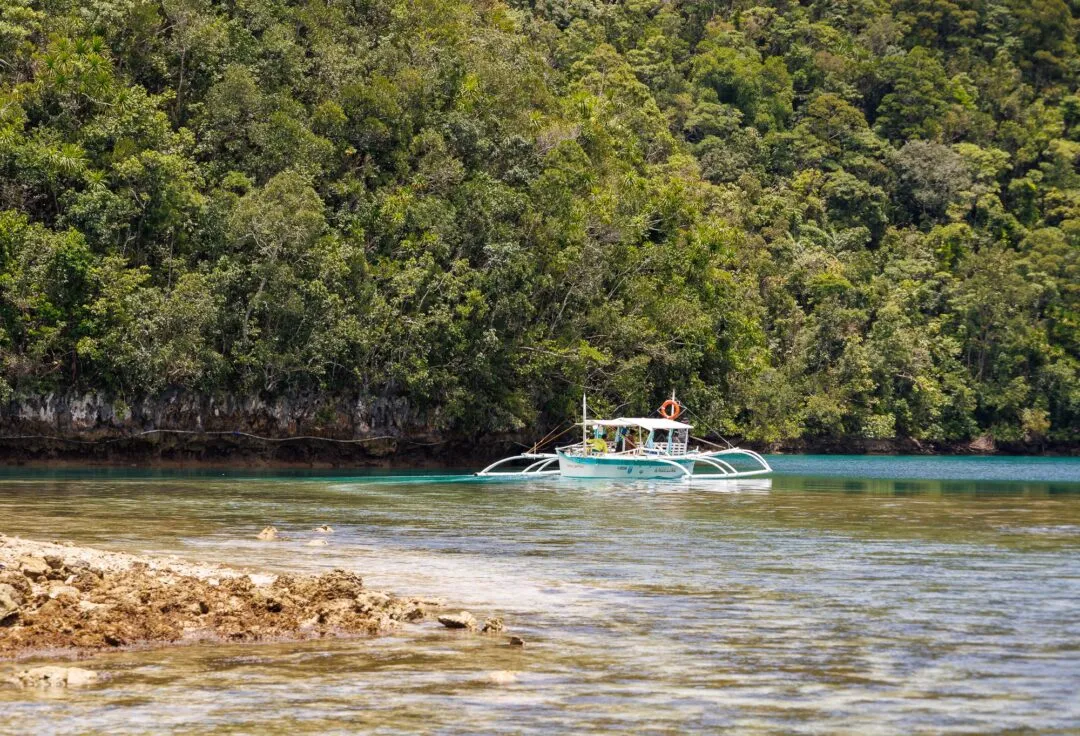 Traditional boat rocky shoreline siargao