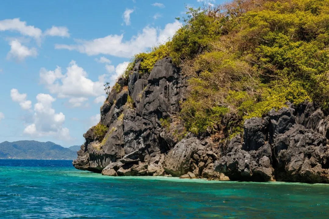 Two banca boats turquoise water karst backdrop El Nido