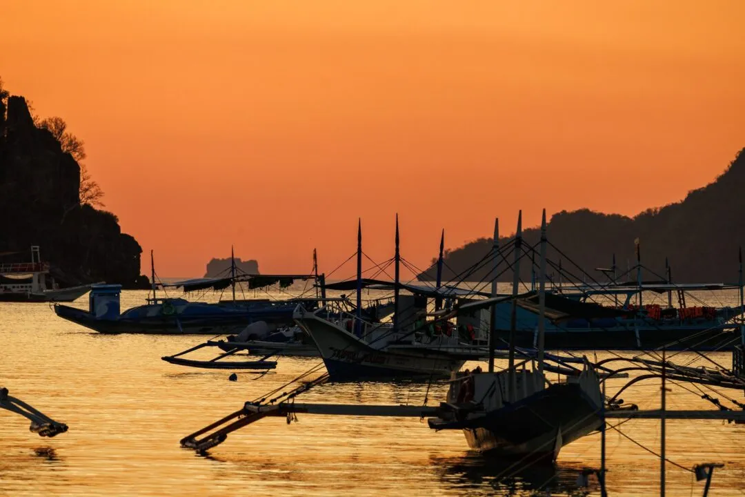 Vivid orange sunset silhouetted bangkas El Nido
